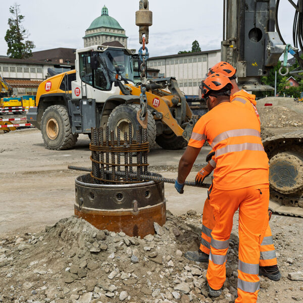 Zwei Bauarbeiter mit grossem Bohrbolzen.