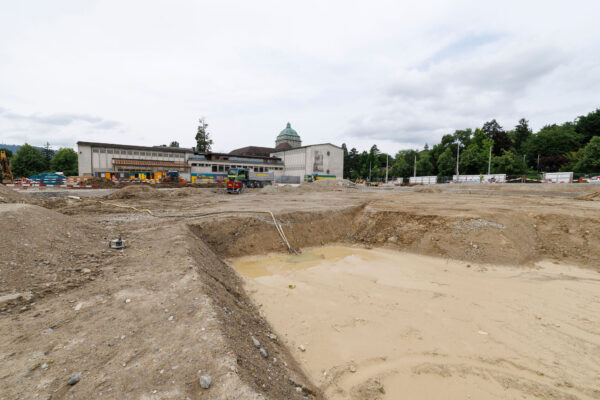 Baustelle mit grossem Graben gefuellt mit Wasser