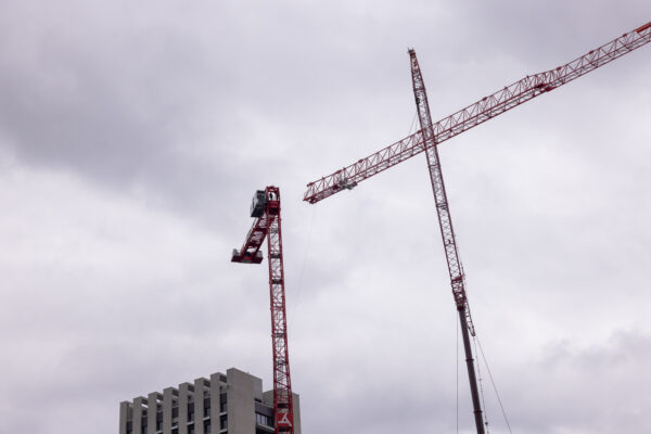 Zwei Pneukrane montieren den Ausleger eines Turmdrehkrans neben dem Careum Hochhaus.