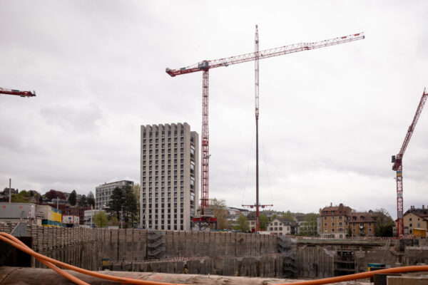 Mehrere aufgebaute Turmdrehkrane im urbanen Umfeld neben dem Careum Hochhaus.